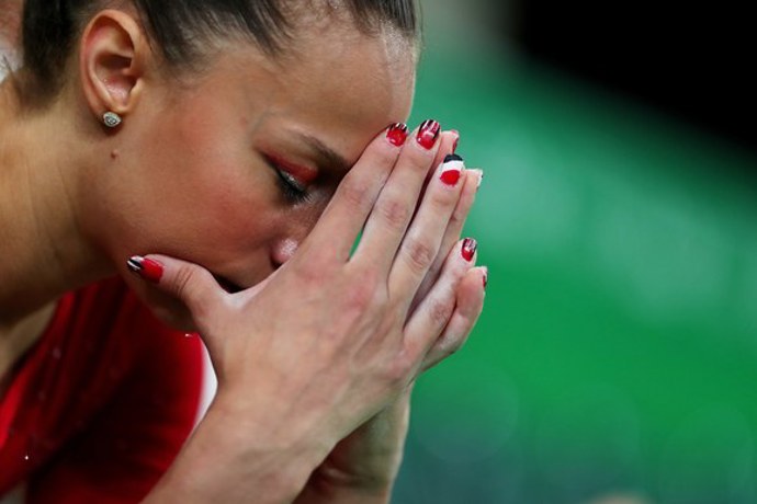 Egyptská gymnastka zachycená při čekání na výsledky, kdy ukazuje i svoji propracovanou manikúru v národních barvách.