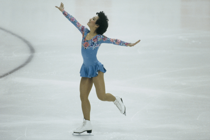 1984 Zimní olympiáda, Sarajevo, Jugoslávie

Americká krasobruslařka Tiffany Chin v nebesky modrém kostýmu. Díky krásnému květovanému motivu na hrudníku a rukávech ani nepotřebovala květiny od svých fanoušků. Po ukončení kariéry v roce 1987 se začala věnovat trénování krasobruslení. Nyní je trenérkou australské krasobruslařky Kailani Crane, která soutěží na letošní zimní olympiádě.
