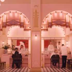 Grand Hotel Budapešť (The Grand Budapest Hotel), 2014
Secesní luxusní hotel pana Gustava (Ralph Fiennes) je zkrátka symfonií barev. Třešňově červené koberce, třpytící se lustry, zelenající se palmy a zdi tak sladce růžové, jako obal čokoládových bonbonů Mendl's. Grand Hotel Budapešť se natáčel v obchodním domě z 20. století ve městě Görlitz na německo-polských hranicích kousek za hranicemi českými. Později byl z honosného hotelu záměrně vytvořen minimalistický interiér, který v prologu představoval hotel ze šedesátých let.
Grand Hotel Budapešť (The Grand Budapest Hotel), 2014
Secesní luxusní hotel pana Gustava (Ralph Fiennes) je zkrátka symfonií barev. Třešňově červené koberce, třpytící se lustry, zelenající se palmy a zdi tak sladce růžové, jako obal čokoládových bonbonů Mendl's. Grand Hotel Budapešť se natáčel v obchodním domě z 20. století ve městě Görlitz na německo-polských hranicích kousek za hranicemi českými. Později byl z honosného hotelu záměrně vytvořen minimalistický interiér, který v prologu představoval hotel ze šedesátých let.