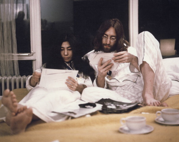 březen 1969

John a Yoko věděli, že se o ně po jejich svatbě začne ohromně zajímat tisk, proto se rozhodli toho využít k propagaci úsilí o světový mír.  Strávili týden (od 25. do 31. března) v prezidentském apartmá číslo 702 v hotelu Hilton v Amsterdamu a mezi devátou ranní a devátou večerní k nim každý den mohli chodit novináři.
