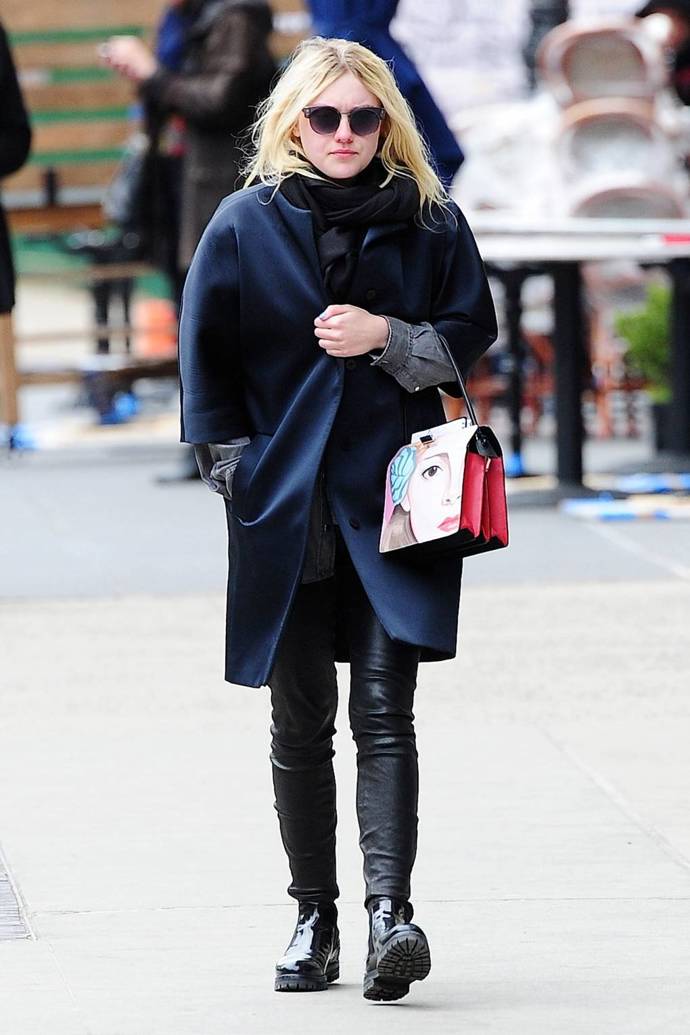 Dakota Fanning ozvláštnila svůj jinak celočerný outfit tmavě modrým kabátem a výraznou Prada kabelkou
