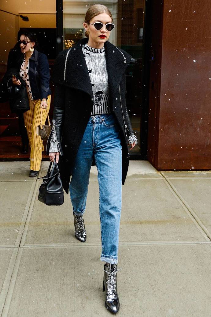 Jako by se nechumelilo - Gigi Hadid kráčí ve sněhové přeháňce v boyfriend džínách, černém kabátu a metalických botách Stuart Weitzman
