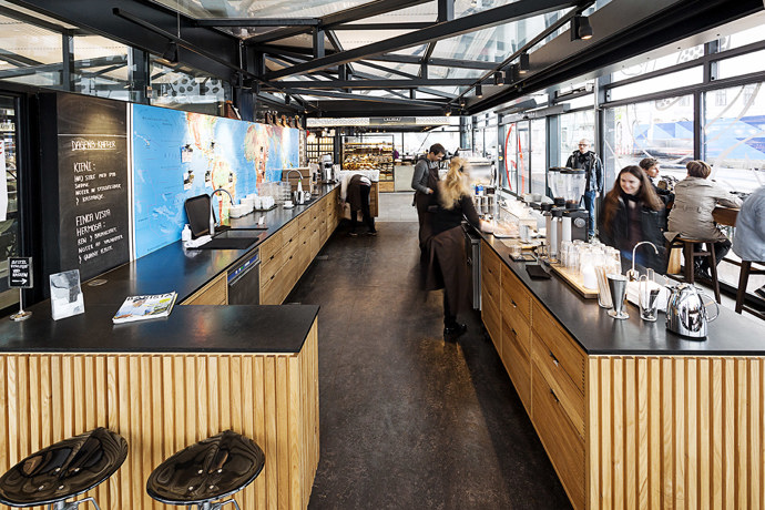 Coffee Collective, Kodaň

Dánské hlavní město se každoročně umisťuje v top 10 nejlepších měst pro život. Není se čemu divit. Dánové vyznávají zdravý životní styl a přesně 62 % jich jezdí do práce každý den na kole, dokonce i v mrazivých dnech a taky jsou milovníci “hygge” – přístupu k životu, jehož základem je hledání štěstí v těch nejzákladnějších životních situacích, třeba u šálku kávy s přáteli. A nevadí, že jsou zrovna na frekventovaném nádráží Nørreport. I v nádražní kavárně Coffee Collective se totiž dá v klidu a bez stresu vychutnat denní dávka kofeinu, navíc v útulném interiéru. Jak jinak. 
