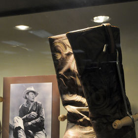 Kostým Johna Wayna z filmu Rooster Cogburn - 167 300 dolarů (v roce 2011 necelé 3 miliony korun)

John Wayne si v tomto kostýmu zahrál postavu Roostera Cogburna. Modrá košile s dlouhým rukávem byla pro Johna Wayna šitá na míru a bunda i košile má nášivku s jeho jménem. Očekávalo se, že se celý kostým vydraží za 164 tisíc dolarů, nakonec se částka za kostým vyšplhala až na 167 300 dolarů a k tomu se ještě páska přes oko vydražila za 47 800 dolarů (asi 850 tisíc korun) a klobouk za 119 500 dolarů (2,1 milionu korun).
