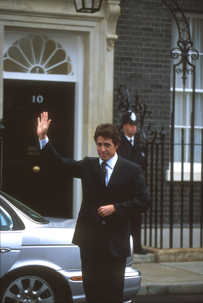 Hugh Grant ztvárnil v Lásce nebeské postavu britského premiéra Davida. Na jeho památnou scénu, jak tančí na schodišti ve svém domě na Downing Street, vzpomínáme dodnes. Pro Brity byla však velmi významná scéna, kde se David na tiskové konferenci tváří v tvář americkému prezidentovi postaví za svoji zemi. K této scéně se dokonce vyjádřil tehdejší britský premiér Tony Blair: "Vím, že jsou zde lidé, kteří by chtěli, abych udělal to samé, jako Hugh Grant v tomto filmu. Ale rozdíl mezi dobrým filmem a reálným životem je v tom, že v životě přijde další den, další rok, budoucnost, která nás nutí zvažovat případné ničivé důsledky našeho jednání, vedoucího k bezprostřednímu úspěchu.
