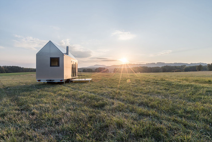 Mobile Hut je moderní domek v hliníkovém designu, přesto svým tvarem inspirovaný klasickým českým domem se sedlovou střechou a komínem.
