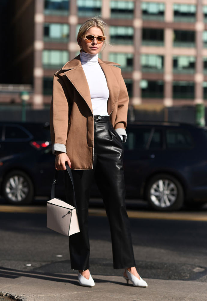 Kožené kalhoty jsou v kombinaci s bílým rolákem a špičatými lodičkami sázkou na jistotu. Odvážíte se doplnit outfit extravagantními slunečními brýlemi?
