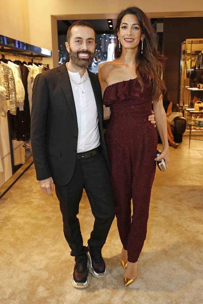 Na otevření butiku Giambattisty Valliho v Londýně na Sloane Street si Amal oblékla vínový overal právě od tohoto návrháře.
