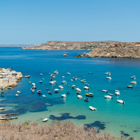 1. Mgarr & Gnejna Bay, Malta

Osada Mgarr na západním pobřeží Malty se může zdát nenápadná, ale nachází se u ní jedna z nejoblíbenějších pláží na ostrově. Zátoku Gnejna s čistě bílým pískem a křišťálově čistou vodou doplňuje skalnatá věž Lippija, která byla postavená na objednávku velmistra Juana de Lascaris-Castellara v roce 1637. Tvořila část pobřežní obrany vytvořené rytíři řádu sv. Jana a dnes je z ní krásná součást krajiny. Nezapomeňte se zastavit v Mgarru, který je proslulý čerstvými jahodami a melouny od místních farmářů – když budete mít štěstí, třeba zastihnete jarní slavnosti jahod Festa Frawli, kde budete moci ochutnat vše možné i nemožné z těchto šťavnatých plodů.

