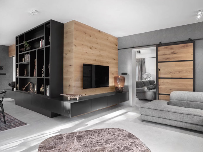Aby architekti vyvážili velké množství šedé barvy, použili v interiéru také hodně dřeva. Prostor zútulní i dobré osvětlení nebo vlněné orientální koberce.
