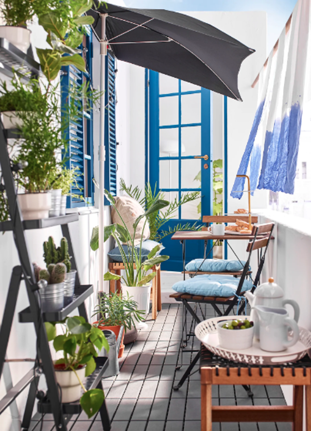 Barevnost tohoto balkonu vychází z modro-bílé kombinace, doplněné zelenými rostlinami a dřevěným nábytkem. Foto: Ikea
