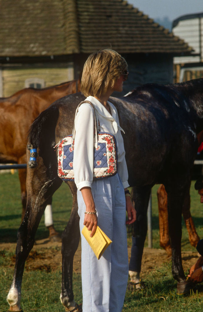 Bílá halenka, pruhované kalhoty a vzorovaná kabelka

Cowdray Park, 1983
