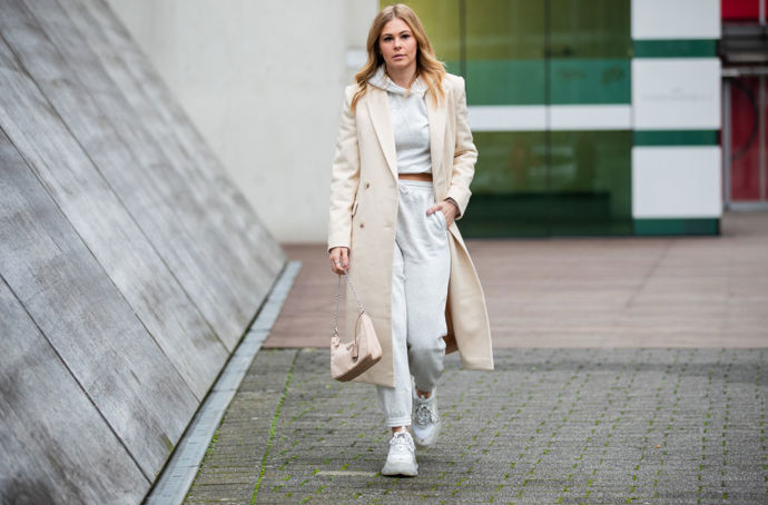 Ladění tón v tónu je trendy i v zimních měsících a šedá tepláková souprava s krémovým kabátem spolu fungují překvapivě skvěle
