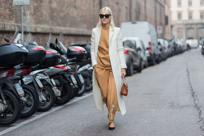 Důkaz, že tepláková souprava jde zkombinovat i do elegantního outfitu s kabátem, kabelkou a balerínami
