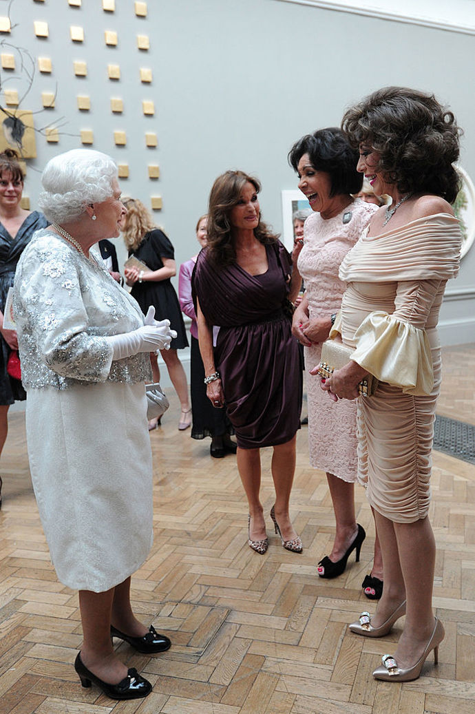 Herečka Joan Collins a zpěvačka Shirley Bassey oblékly na setkání s královnou v Royal Academy of Arts v roce 2012 světle růžové šaty v délce po kolena.

