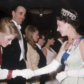 Francouzská herečka Catherine Deneuve se s Alžbětou II. setkala v roce 1966 v Londýně. Na sobě měla krémové šaty s červeným zdobením.
