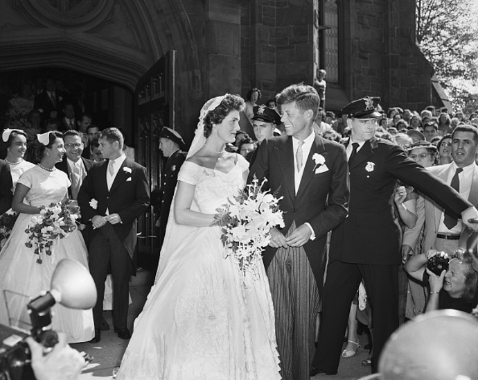 50. léta – Jackie Kennedy a John Fitzgerald Kennedy
V anketách o nejkrásnější svatební pár historie se na předních místech neustále umísťuje budoucí prezident USA a jeho půvabná snoubenka Jackie.
Seznámili se na večeři u přátel, poté spolu randili dva roky, než John poklekl a talentované novinářce na prst navlékl zásnubní prsten s diamantem, který měl skoro tři karáty a byl ozdoben smaragdem. Ano, tušíte správně, nevěsta řekla ano, a velkolepé svatbě nestálo nic v cestě.
V osudový den – 12. září 1953 se více jak 800 významných hostů z řad senátorů či diplomatů sjelo do kostela Panny Marie v New Portu, oblíbeného místa obou svatebčanů (při nedělních bohoslužbách sedávali ruku v ruce v desáté řadě).
Tentokrát se však nevěsta prošla uličkou doprovázená tóny Bachovy skladby Ave Maria oděná do oslnivých šatů návrhářky Ann Lowe. Na tuto skvostnou hedvábnou róbu barvy slonová kost bylo spotřebováno více jak 50 metrů látky. Za šperky si nevěsta zvolila perlový náhrdelník a diamantový náramek – dar od ženicha.
Jen málokdo tušil, že pár dní před obřadem zachvátil návrhářské studio požár, a šaty včetně těch pro družičky, byly zničeny. Švadleny tak musely šít prakticky bez přestávky, aby vše stihly do svatebního dnu.
Jako kdyby tato událost byla předzvěstí tragédie, která za deset let postihne tento dokonalý pár.
50. léta – Jackie Kennedy a John Fitzgerald Kennedy
V anketách o nejkrásnější svatební pár historie se na předních místech neustále umísťuje budoucí prezident USA a jeho půvabná snoubenka Jackie.
Seznámili se na večeři u přátel, poté spolu randili dva roky, než John poklekl a talentované novinářce na prst navlékl zásnubní prsten s diamantem, který měl skoro tři karáty a byl ozdoben smaragdem. Ano, tušíte správně, nevěsta řekla ano, a velkolepé svatbě nestálo nic v cestě.
V osudový den – 12. září 1953 se více jak 800 významných hostů z řad senátorů či diplomatů sjelo do kostela Panny Marie v New Portu, oblíbeného místa obou svatebčanů (při nedělních bohoslužbách sedávali ruku v ruce v desáté řadě).
Tentokrát se však nevěsta prošla uličkou doprovázená tóny Bachovy skladby Ave Maria oděná do oslnivých šatů návrhářky Ann Lowe. Na tuto skvostnou hedvábnou róbu barvy slonová kost bylo spotřebováno více jak 50 metrů látky. Za šperky si nevěsta zvolila perlový náhrdelník a diamantový náramek – dar od ženicha.
Jen málokdo tušil, že pár dní před obřadem zachvátil návrhářské studio požár, a šaty včetně těch pro družičky, byly zničeny. Švadleny tak musely šít prakticky bez přestávky, aby vše stihly do svatebního dnu.
Jako kdyby tato událost byla předzvěstí tragédie, která za deset let postihne tento dokonalý pár.