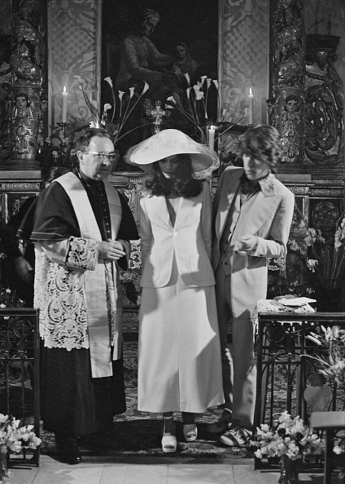 70. léta – Mick Jagger a Bianca Jagger
Svatba zbavená všech tradic a zvyků, tak by se dal nazvat sňatek Micka Jaggera a jeho extravagantní ženy Biancy.
Modelka a právnička nikaragujského původu Bianca des Macias ráda vybočovala z davu, ostatně to byl prý jeden z důvodů, proč tak zaujala rozjíveného frontmana skupiny Rolling Stones. Je tedy nad míru jasné, že zde bychom klasické svatební šaty se spořádanou hostinou jen těžko pohledali.
Bianca ve svůj velký den 12. května 1971 oslnila přítomné hosty v Saint Tropez bílým kostýmkem z dílny návrhářského mistra Yvese Saint Laurenta. A to by nebyla ona, aby ani ve svatební den trochu nešokovala. Pod bílým sakem totiž už nic jiného neměla. Šušká se, že tento módní výstřelek musela nevěsta zvolit kvůli tomu, že vzhledem ke svému těhotenství se do připravené košile již nevešla.
A přestože bychom tomu páru jistě přáli, aby pro ně platilo, ono pohádkové „žili šťastně až do smrti“, v tomto případě se zázrak nekonal a rockový bouřlivák nebyl zkrocen. Jako důvod rozvodu, sedm let od svatby uvedla Bianca Jagger cizoložství.
70. léta – Mick Jagger a Bianca Jagger
Svatba zbavená všech tradic a zvyků, tak by se dal nazvat sňatek Micka Jaggera a jeho extravagantní ženy Biancy.
Modelka a právnička nikaragujského původu Bianca des Macias ráda vybočovala z davu, ostatně to byl prý jeden z důvodů, proč tak zaujala rozjíveného frontmana skupiny Rolling Stones. Je tedy nad míru jasné, že zde bychom klasické svatební šaty se spořádanou hostinou jen těžko pohledali.
Bianca ve svůj velký den 12. května 1971 oslnila přítomné hosty v Saint Tropez bílým kostýmkem z dílny návrhářského mistra Yvese Saint Laurenta. A to by nebyla ona, aby ani ve svatební den trochu nešokovala. Pod bílým sakem totiž už nic jiného neměla. Šušká se, že tento módní výstřelek musela nevěsta zvolit kvůli tomu, že vzhledem ke svému těhotenství se do připravené košile již nevešla.
A přestože bychom tomu páru jistě přáli, aby pro ně platilo, ono pohádkové „žili šťastně až do smrti“, v tomto případě se zázrak nekonal a rockový bouřlivák nebyl zkrocen. Jako důvod rozvodu, sedm let od svatby uvedla Bianca Jagger cizoložství.