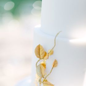 Minimalisticky provedené dorty jsou velmi trendy. Hladká bílá struktura kontrastuje s elegantním zlatým zdobením. Foto: Matěj Třasák. Výzdoba: Ivan Šablatúra.
