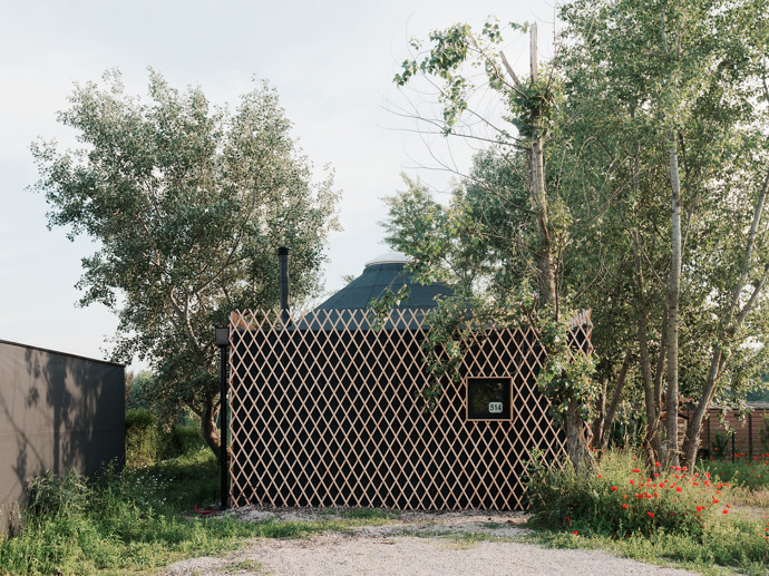 Tvar tradiční kruhové jurty uchvátil mladý manželský pár, který si chtěl postavit víkendový domek. Architekti jim přání splnili a vytvořili jednoduchou dřevostavbu, která zadání dokonale splňuje. 
