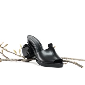Dřeváky s neobvyklým podpatkem spojují hned dva trendy letošního jara dohromady. Elegantní černá navíc dokáže opticky zeštíhlit i silnější chodidla.
