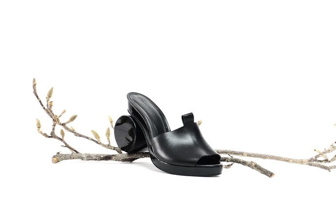 Dřeváky s neobvyklým podpatkem spojují hned dva trendy letošního jara dohromady. Elegantní černá navíc dokáže opticky zeštíhlit i silnější chodidla.

