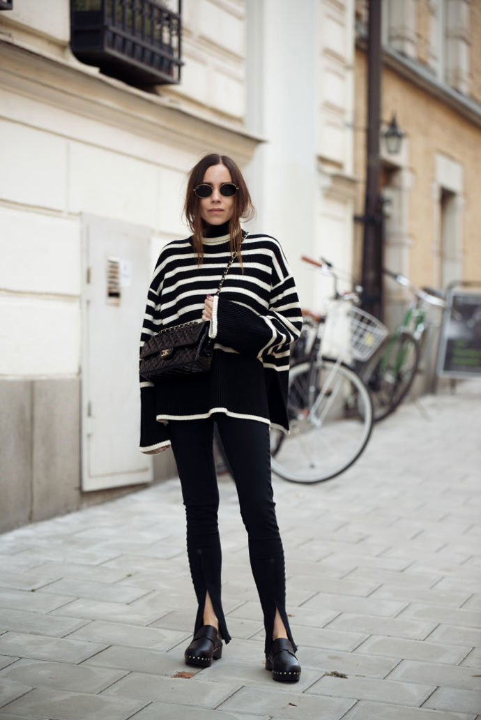 Černý svetr s bílými pruhy v oversized střihu je velmi elegantním a stylovým kouskem do podzimního šatníku.
