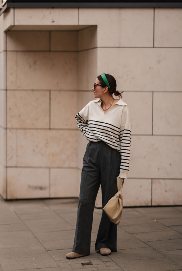 Minimalistický outfit v podobě pruhovaného svetru a šedých kalhot v pánském stylu snadno rozzáříte třeba barevnou čelenkou.
