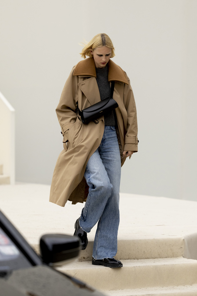 Opět široké džíny, tentokrát v kombinaci s oversized kabátem a černou kabelkou Jil Sander.
