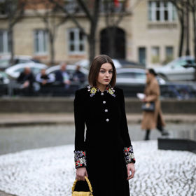 Černý elegantní kabát rozzáří barevné výšivky na rukávech i kolem krku.
