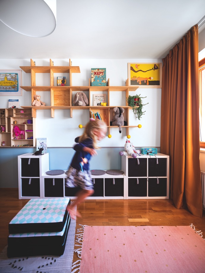 Ještě před pár měsíci tu byla ložnice rodičů a maličký Filip se čtyřletou Elou měli zázemí ve vedlejší místnosti. Ve spolupráci s designérkou se bytová konstelace prohodila a z původního vybavení ložnice zbyly jen zatemňovací závěsy. Jejich výrazná barva inspirovala k ladění celého pokoje.
