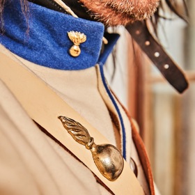 Hořící granát jako hlavní symbol granátníků nemůže na uniformách chybět. Zdobí „patrontašku“ i kožené řemeny. 
