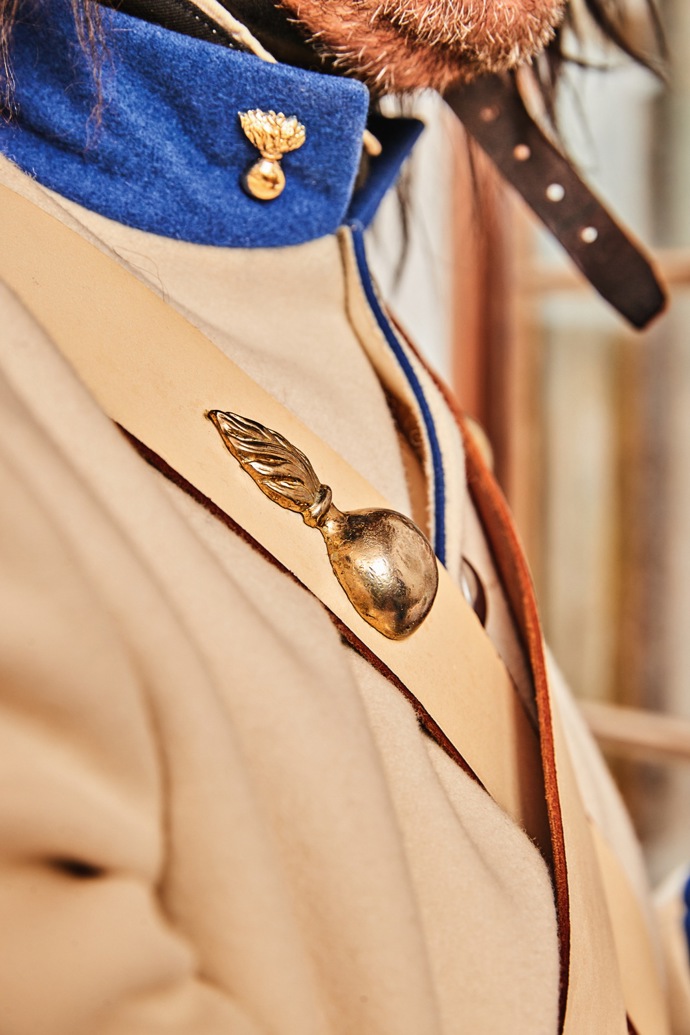 Hořící granát jako hlavní symbol granátníků nemůže na uniformách chybět. Zdobí „patrontašku“ i kožené řemeny.
Hořící granát jako hlavní symbol granátníků nemůže na uniformách chybět. Zdobí „patrontašku“ i kožené řemeny.