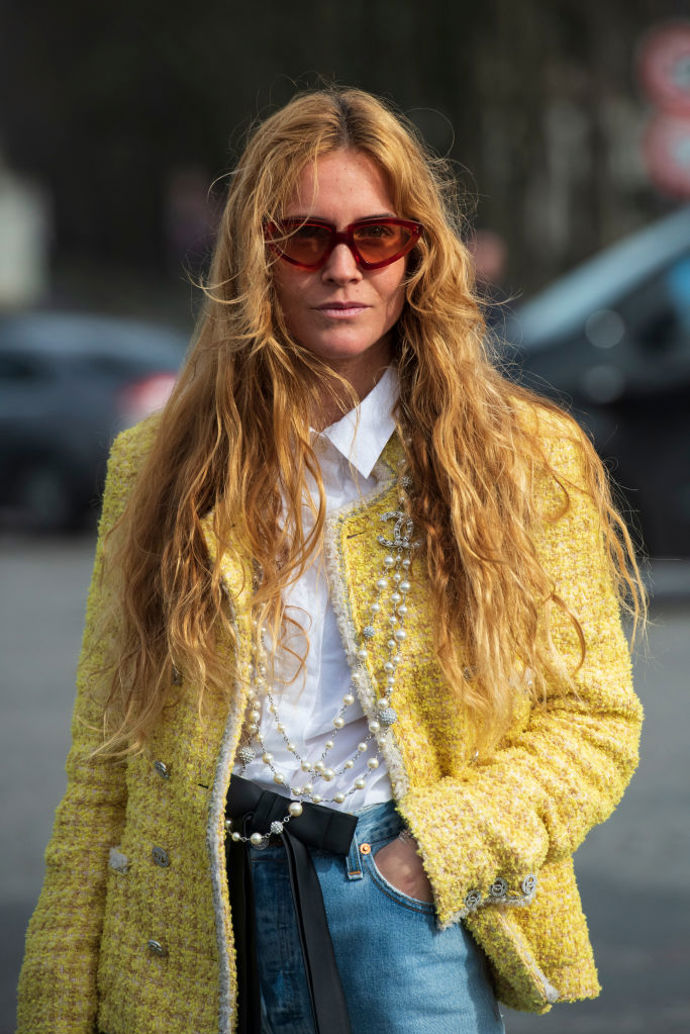 Bílá košile, tvídové sako a dlouhé perlové náhrdelníky tvoří ikonický Chanel look.
