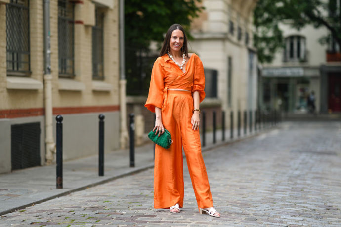 Zářivě oranžový komplet, zelená kabelka a perly? Proč ne, podle nás jde o ideální outfit na večírek na dovolené u moře.

