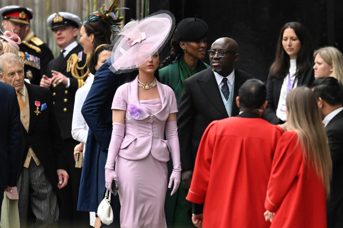 Na korunovaci dorazila v růžovém kostýmku s rukavičkami a kloboukem i zpěvačka Katy Perry.
