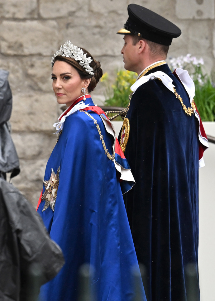 Princezna a princ z Walesu na korunovaci samozřejmě nechyběli. Kate má na sobě šaty od Alexandra McQueena (který stál za jejími svatebními šaty z roku 2011) z hedvábného krepu slonové kosti se stříbrnými pruty a nitěmi s výšivkou s motivy růže, bodláku, narcisu a jetele.

