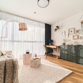 Mladá žena oslovila autorku s tím, aby jí zařídila malometrážní byt tak, aby byl funkční, vkusný a minimalistický. Základní barvou v interiéru je bílá, kterou doplňuje béžová, tmavošedá a černá. Nábytek má čisté linie, místy je až stroze geometrický. Minimalistický kov se sklem je vhodně doplněn dřevem.
