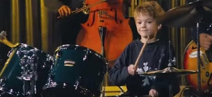 Thomas Brodie-Sangster hrající na bicí ve snímku Láska nebeská
Thomas Brodie-Sangster hrající na bicí ve snímku Láska nebeská