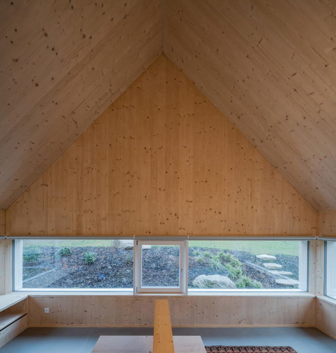 Modrý šindelový obklad a elegantní bílé rámy oken vytvářejí kontrast, který nemůžete přehlédnout. Architektka Markéta Cajthamlová a její tým se postarali o každý detail, ať už jde o interiér plný dřeva nebo promyšlenou dispozici, která nabídne vše, co potřebujete.

