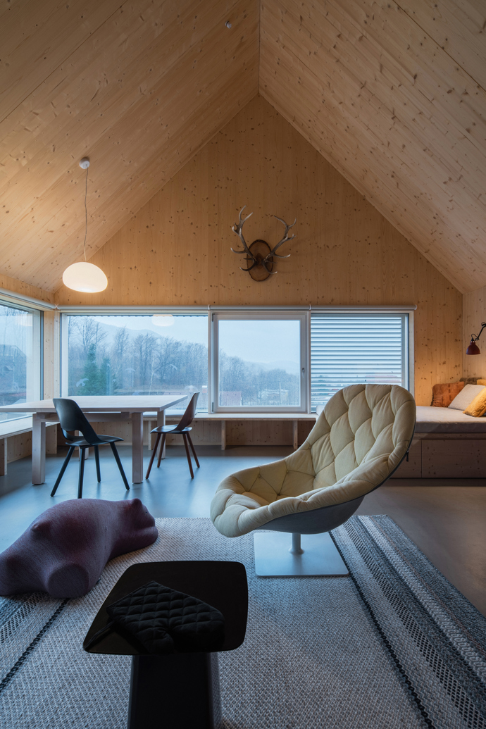 Modrý šindelový obklad a elegantní bílé rámy oken vytvářejí kontrast, který nemůžete přehlédnout. Architektka Markéta Cajthamlová a její tým se postarali o každý detail, ať už jde o interiér plný dřeva nebo promyšlenou dispozici, která nabídne vše, co potřebujete.

