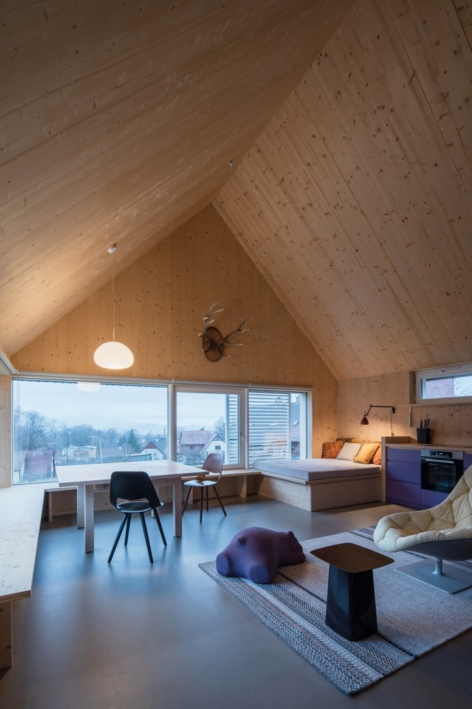 Modrý šindelový obklad a elegantní bílé rámy oken vytvářejí kontrast, který nemůžete přehlédnout. Architektka Markéta Cajthamlová a její tým se postarali o každý detail, ať už jde o interiér plný dřeva nebo promyšlenou dispozici, která nabídne vše, co potřebujete.

