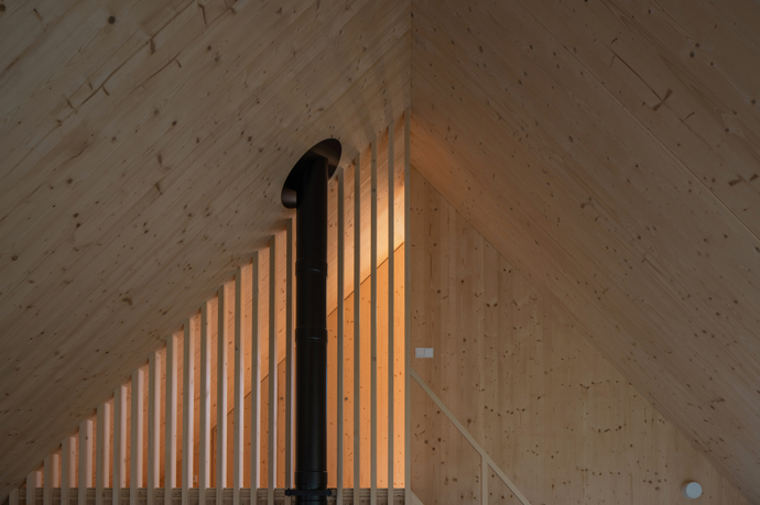 Modrý šindelový obklad a elegantní bílé rámy oken vytvářejí kontrast, který nemůžete přehlédnout. Architektka Markéta Cajthamlová a její tým se postarali o každý detail, ať už jde o interiér plný dřeva nebo promyšlenou dispozici, která nabídne vše, co potřebujete.
