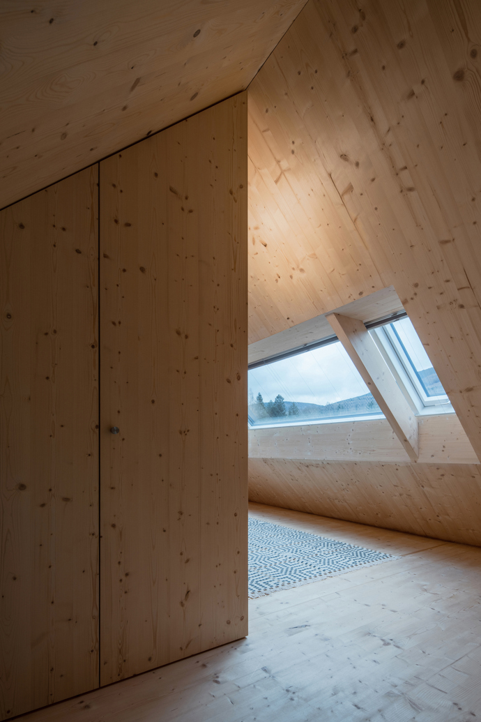 Modrý šindelový obklad a elegantní bílé rámy oken vytvářejí kontrast, který nemůžete přehlédnout. Architektka Markéta Cajthamlová a její tým se postarali o každý detail, ať už jde o interiér plný dřeva nebo promyšlenou dispozici, která nabídne vše, co potřebujete.
