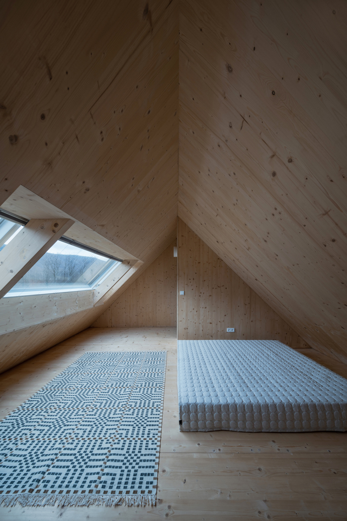 Modrý šindelový obklad a elegantní bílé rámy oken vytvářejí kontrast, který nemůžete přehlédnout. Architektka Markéta Cajthamlová a její tým se postarali o každý detail, ať už jde o interiér plný dřeva nebo promyšlenou dispozici, která nabídne vše, co potřebujete.
