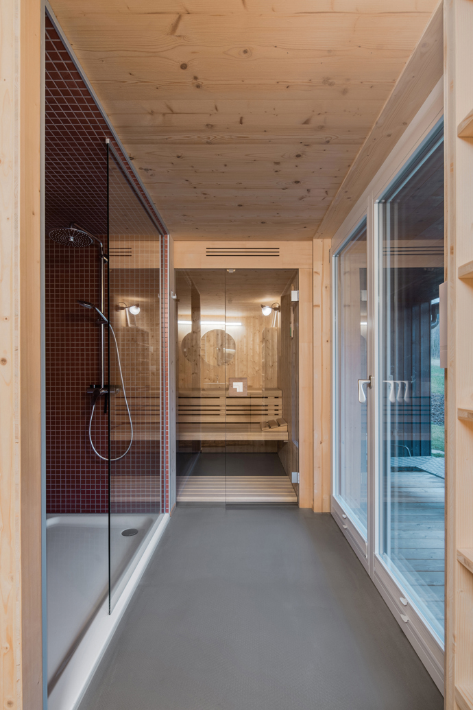 Modrý šindelový obklad a elegantní bílé rámy oken vytvářejí kontrast, který nemůžete přehlédnout. Architektka Markéta Cajthamlová a její tým se postarali o každý detail, ať už jde o interiér plný dřeva nebo promyšlenou dispozici, která nabídne vše, co potřebujete.
