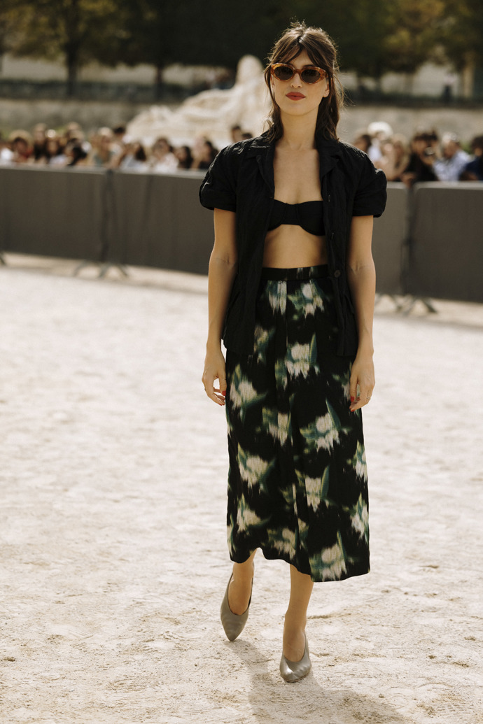 Jeanne Damas na přehlídku Dior oblékla vzorovanou sukni, černou rozepnutou blůzu a černou podprsenku.
