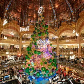 Galeries Lafayette: Pařížský secesní klenot

Jeden z nejkrásnějších obchodních domů na světě se nachází v samém centru Paříže na Boulevard Haussmann. Galeries Lafayette ovšem nebyl od začátku několikaposchoďový obchodní dům. Théophile Bader a jeho bratranec Alphonse Kahn si na rohu ulic La Fayette a Chaussée-d’Antin v roce 1894 otevřeli malý obchůdek s galanterií. Protože se jim dařilo, začali postupně skupovat okolní domy, povolali architekta Georgese Chedanna a v roce 1912 se otevíral obchodní dům jménem Galeries Lafayette.

Protože hned za rohem leží pařížská opera, jsou balkony v atriu obchodního domu inspirované právě těmi v budově opery. Interiér dodnes nezapře dobu, v níž vznikl. Zdobení ve stylu belle époque a secese najdeme na schodištích i balkonech a nejtypičtějším znakem je samozřejmě skleněná kopule vévodící celému interiéru. Galeries Lafayette rozhodně stojí za návštěvu, i kdybyste se zrovna nechystala na nákupy. Dokonce se můžete vydat na komentovanou prohlídku celé budovy. A nezapomeňte na střechu, je z ní krásný výhled na Paříž i s Eiffelovkou!
