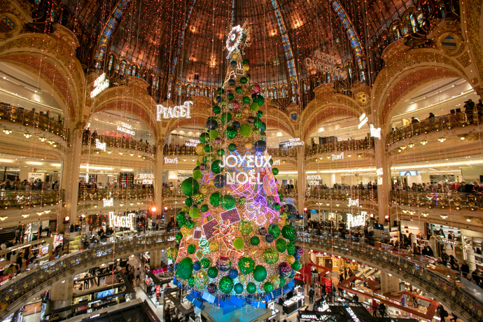 Galeries Lafayette: Pařížský secesní klenot

Jeden z nejkrásnějších obchodních domů na světě se nachází v samém centru Paříže na Boulevard Haussmann. Galeries Lafayette ovšem nebyl od začátku několikaposchoďový obchodní dům. Théophile Bader a jeho bratranec Alphonse Kahn si na rohu ulic La Fayette a Chaussée-d’Antin v roce 1894 otevřeli malý obchůdek s galanterií. Protože se jim dařilo, začali postupně skupovat okolní domy, povolali architekta Georgese Chedanna a v roce 1912 se otevíral obchodní dům jménem Galeries Lafayette.

Protože hned za rohem leží pařížská opera, jsou balkony v atriu obchodního domu inspirované právě těmi v budově opery. Interiér dodnes nezapře dobu, v níž vznikl. Zdobení ve stylu belle époque a secese najdeme na schodištích i balkonech a nejtypičtějším znakem je samozřejmě skleněná kopule vévodící celému interiéru. Galeries Lafayette rozhodně stojí za návštěvu, i kdybyste se zrovna nechystala na nákupy. Dokonce se můžete vydat na komentovanou prohlídku celé budovy. A nezapomeňte na střechu, je z ní krásný výhled na Paříž i s Eiffelovkou!
