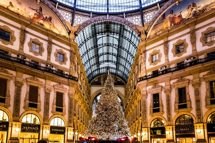 Galleria Vittorio Emanuele II: Startovní čára pro Pradu

Milánskou katedrálu Duomo a budovu slavné opery La Scala spojuje nejstarší obchodní dům v celé Itálii. Architekt Giuseppe Mengoni dokončil tuto nákupní pasáž se čtyřmi křídly a skleněnou kopulí v roce 1867 a město Milán se rozhodlo ji pojmenovat po prvním králi sjednocené Itálie, Viktorovi Emanuelovi II. V bohatě zdobené průchozí galerii najdete ty nejluxusnější značky, jako jsou Prada, Versace nebo Gucci. Zdejší obchod Prady byl dokonce teprve druhý, který značka kdy otevřela.

Výlohy obchodů jsou vždy dotažené do posledního detailu a často se obměňují. Značky, které v galerii chtějí mít svůj obchod, musejí ale dodržovat jistá pravidla. Například název obchodu musí být napsaný zlatým písmem v černém poli, aby se zachoval původní jednotný design. Kromě obchodů zde najdete také proslulé milánské restaurace jako Biffi nebo Savini. V prosinci zdobí střed galerie vánoční strom, který byl v minulých letech osázený až 35 tisíci světýlky. Při návštěvě pasáže si také rozhodně nenechte ujít příležitost podívat se i na střechu.
